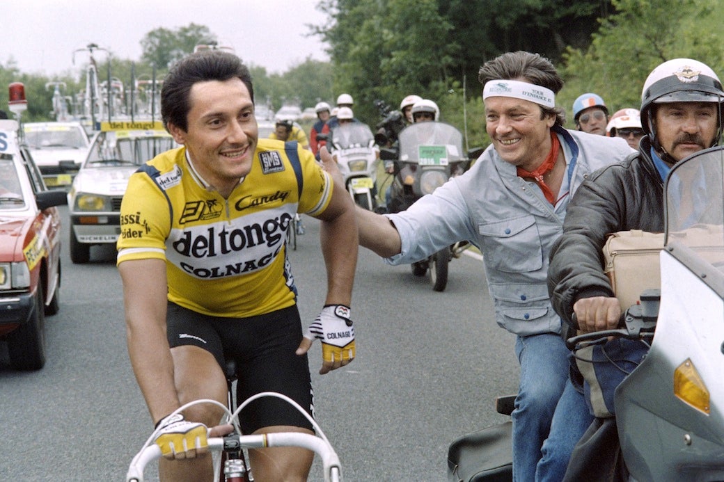 French actor Alain Delon encourages Italian Giuseppe Saronni (R) during the 7th stage of the 74th Tour de France cycling race run between Epinal and Troyes, on July 7, 1987.  AFP PHOTO