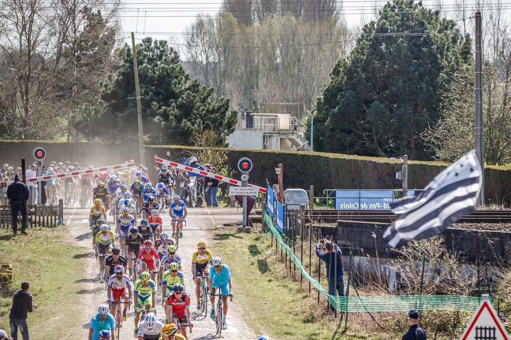 The Paris-Roubaix peloton cut things far too close as several riders crossed high-speed train tracks while the barriers were coming down. Photo: Iri Greco / BrakeThrough Media
