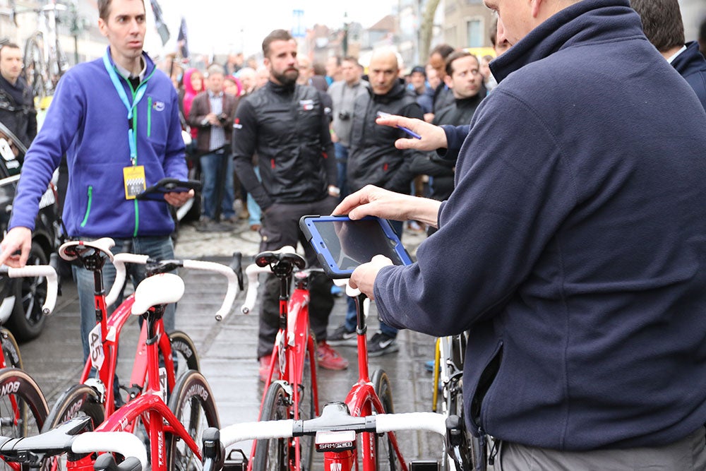 A UCI official uses an iPad to check each bike for motors. There were several officials on hand to scan each and every bike in the pit area, even spares. Photo: Dan Cavallari | VeloNews
