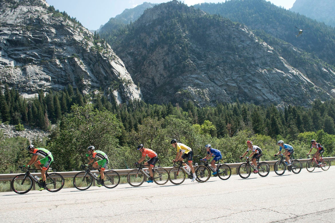 The rock cliffs of Little Cottonwood Canyon tower over the yellow jersey group. Photo: Casey B. Gibson | <a href="http://www.cbgphoto.com">www.cbgphoto.com</a>