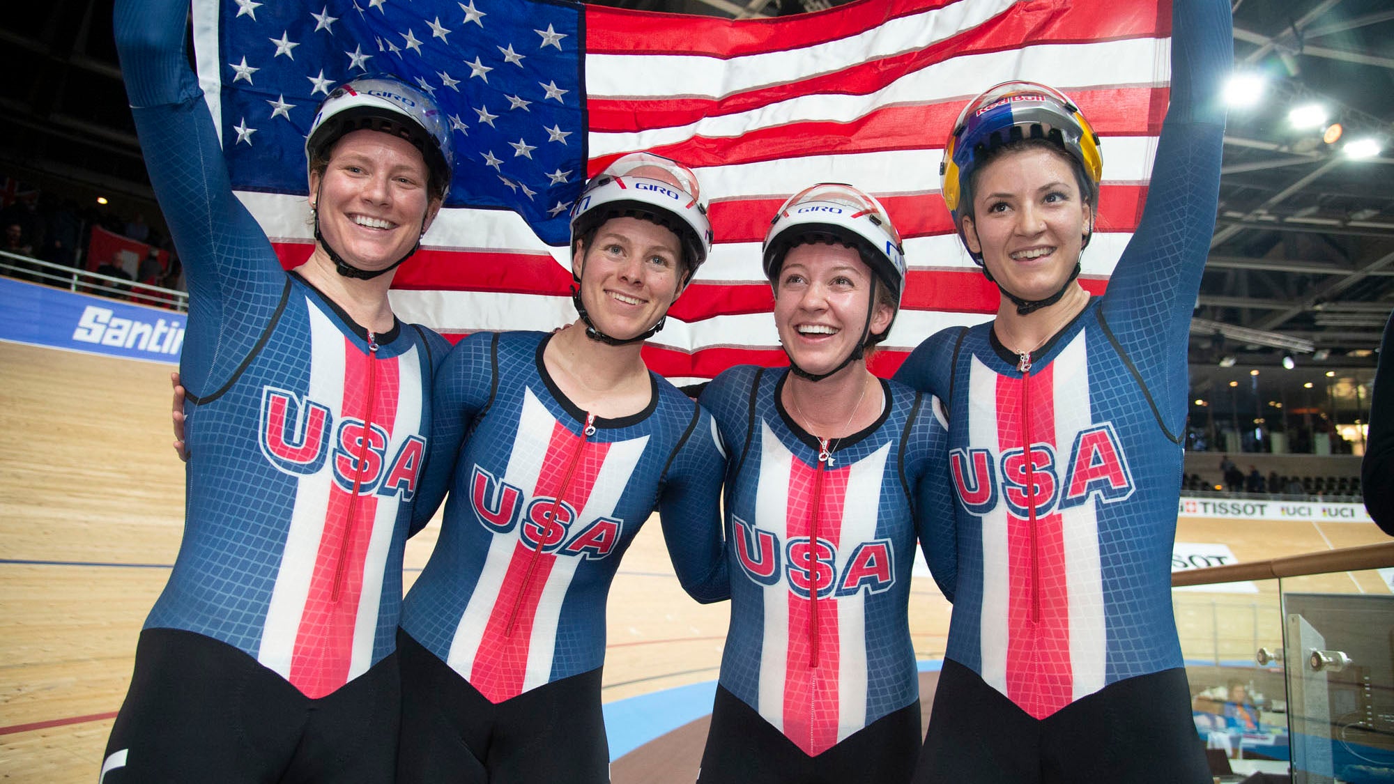 LIly Williams, Jenn Valente, Emma White, and Chloe Dygert  celebrate with the flag after their gold medal ride this winter. Photo: Casey B. Gibson | <a href="http://www.cbgphoto.com">www.cbgphoto.com</a>
