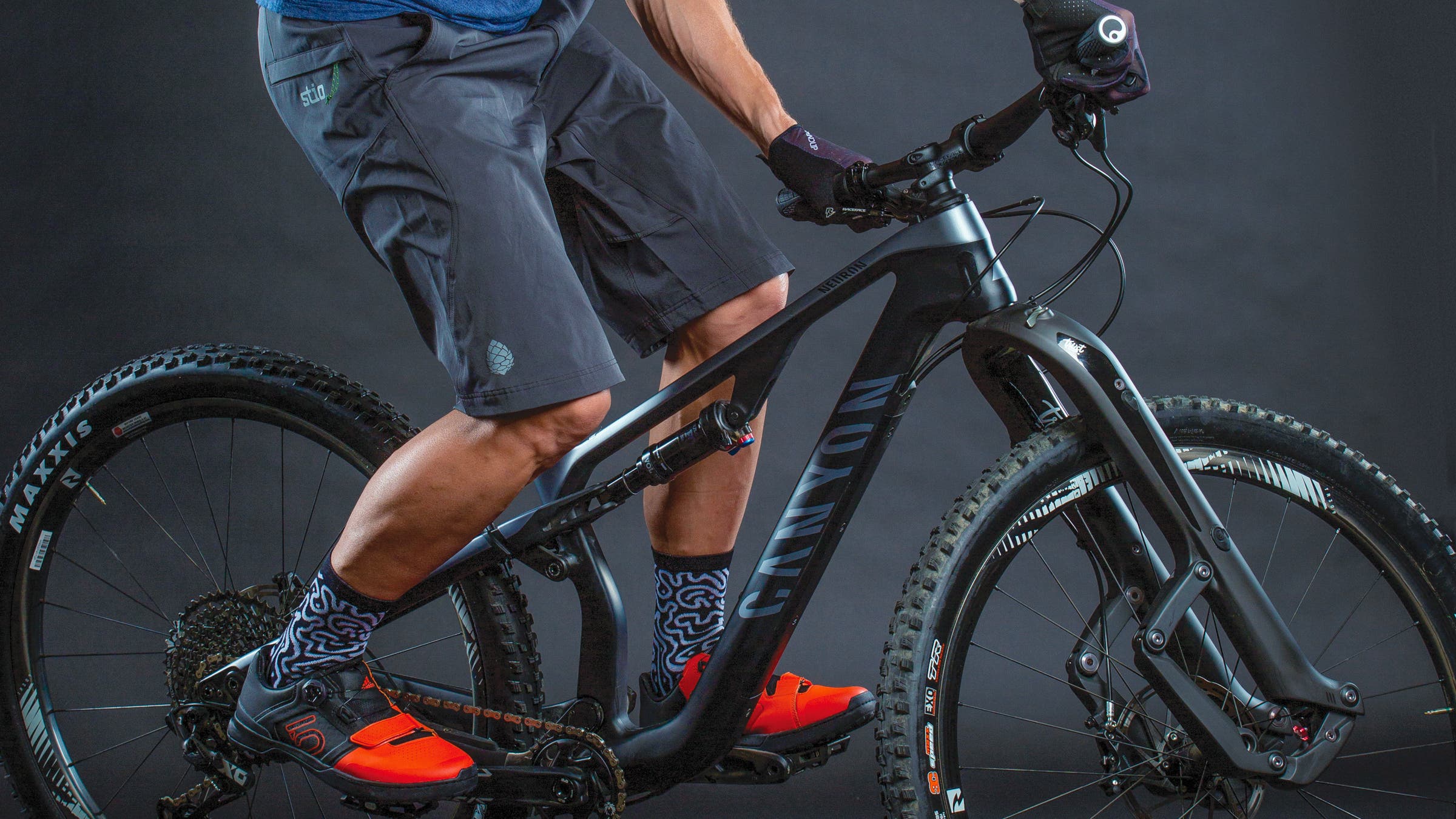 Close-up of man on mountain bike wearing shorts and mountain bike shoes