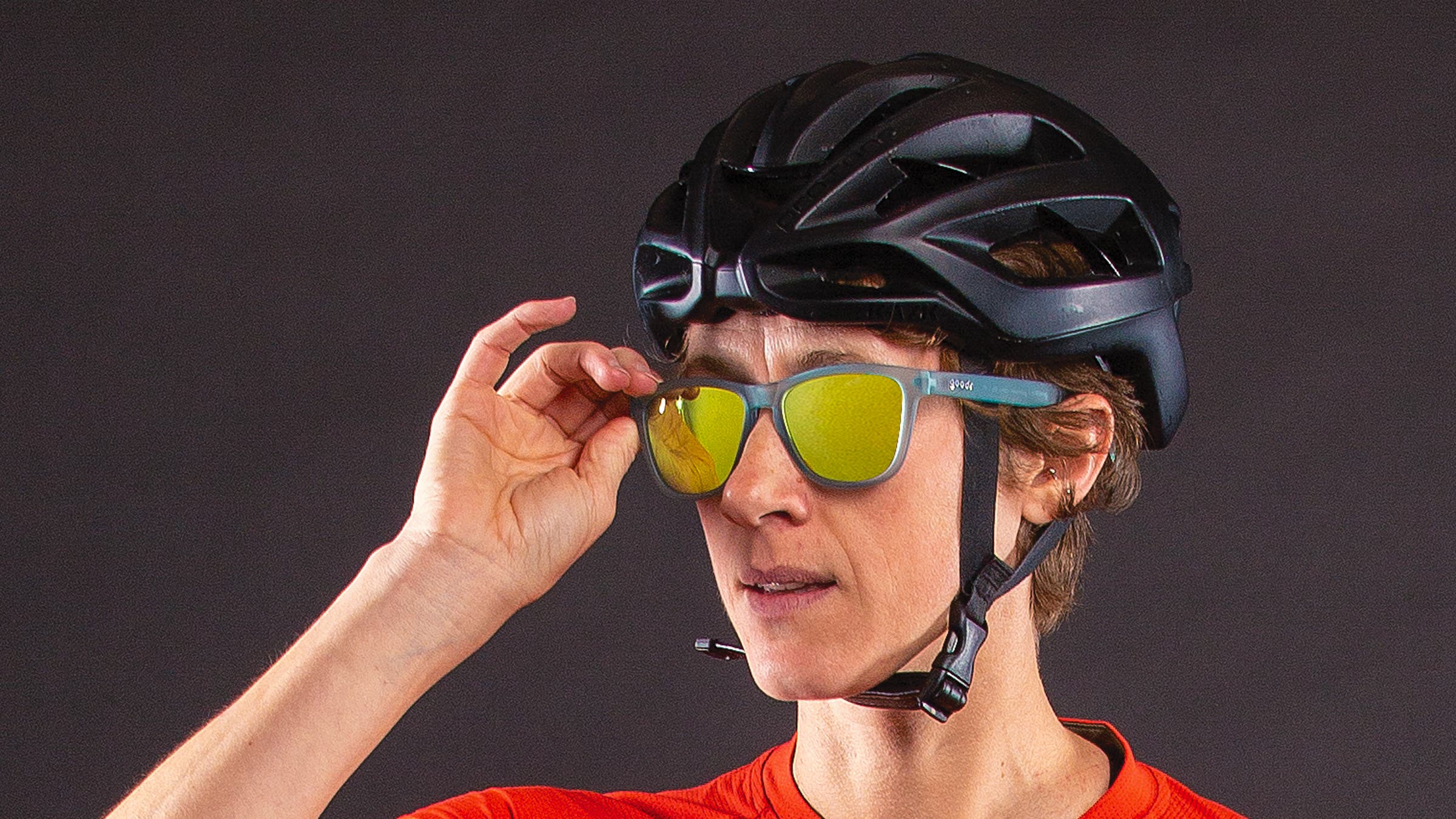 Close-up of woman wearing cycling helmet adjusting her sunglasses