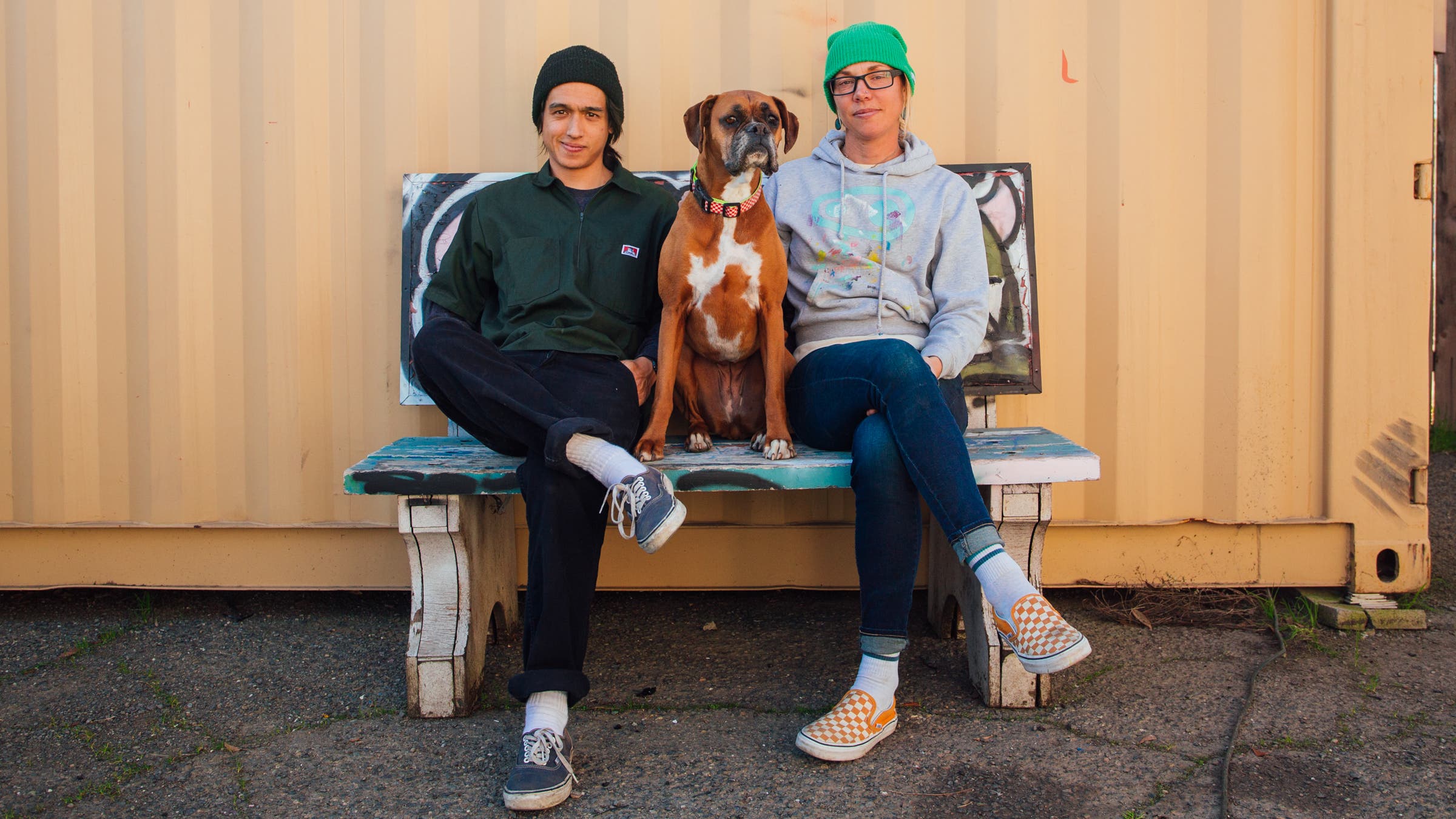 A dog sits in between Chris Namba and Emily Kachorek