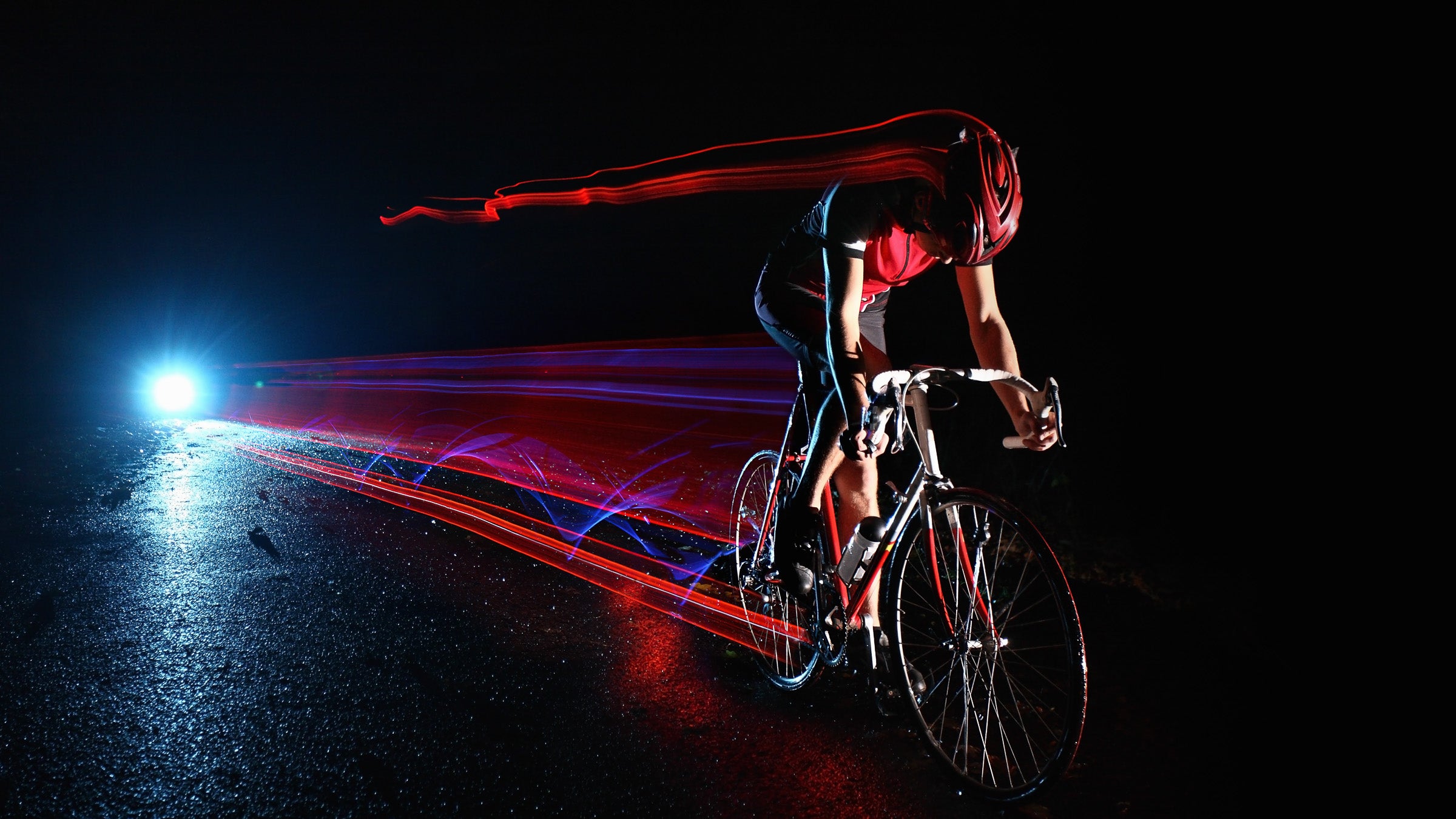 Cyclist riding at night leaving streaks of light