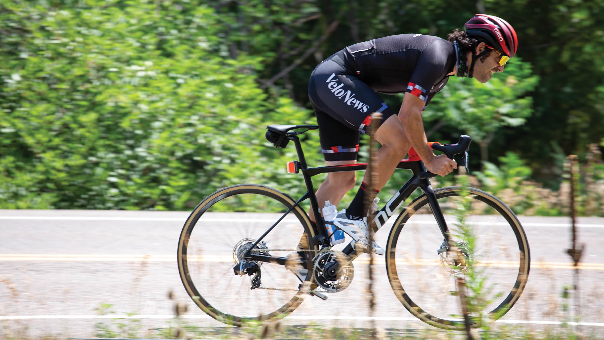Cyclist riding out of the saddle of a bike with a dropped seatstay