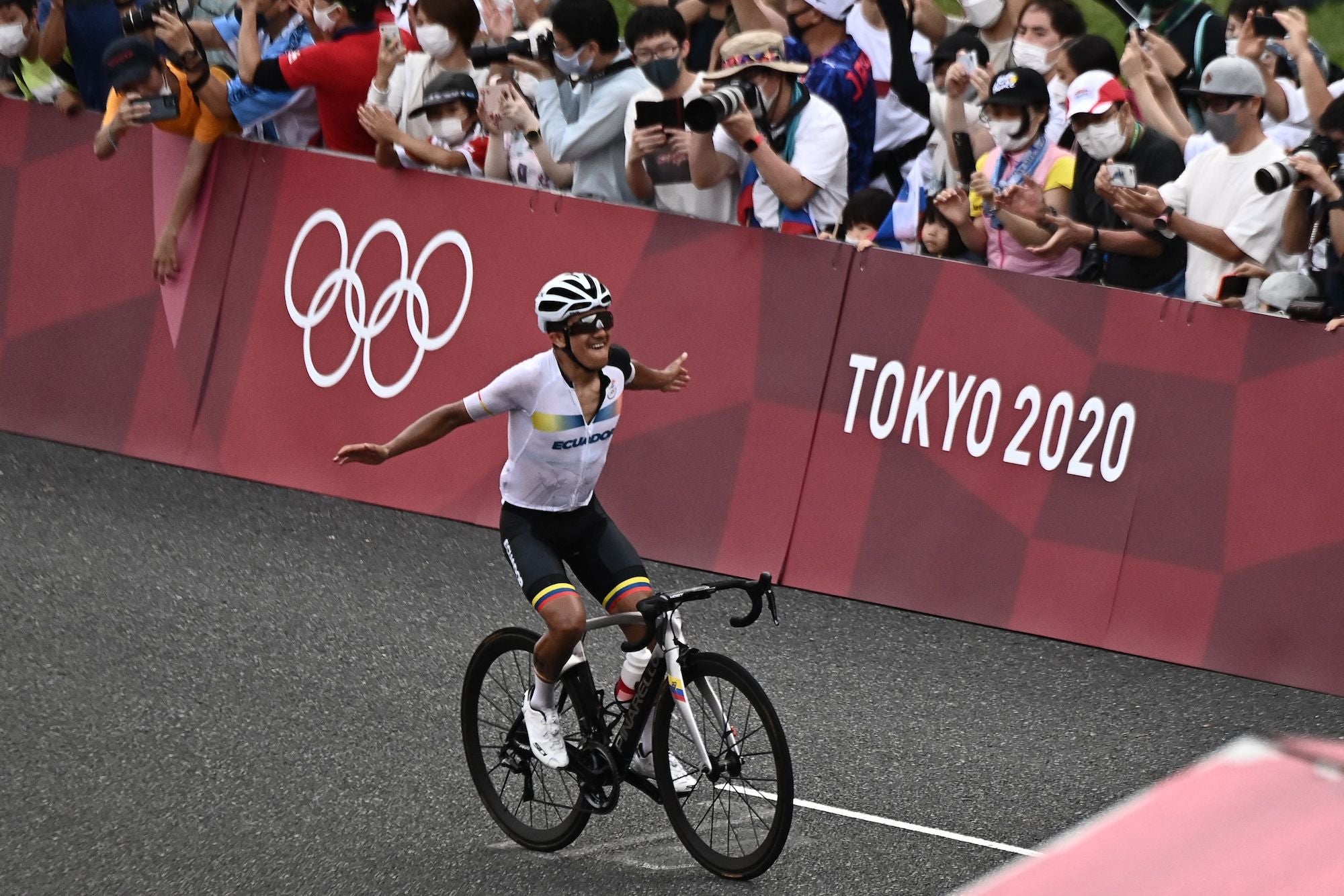 Ecuador's Richard Carapaz celebrates as he rides to the finish line to win the men's cycling road race during the Tokyo 2020 Olympic Games at the Fuji International Speedway in Oyama, Japan, on July 24, 2021. (Photo by Jeff PACHOUD / AFP) (Photo by JEFF PACHOUD/AFP via Getty Images)