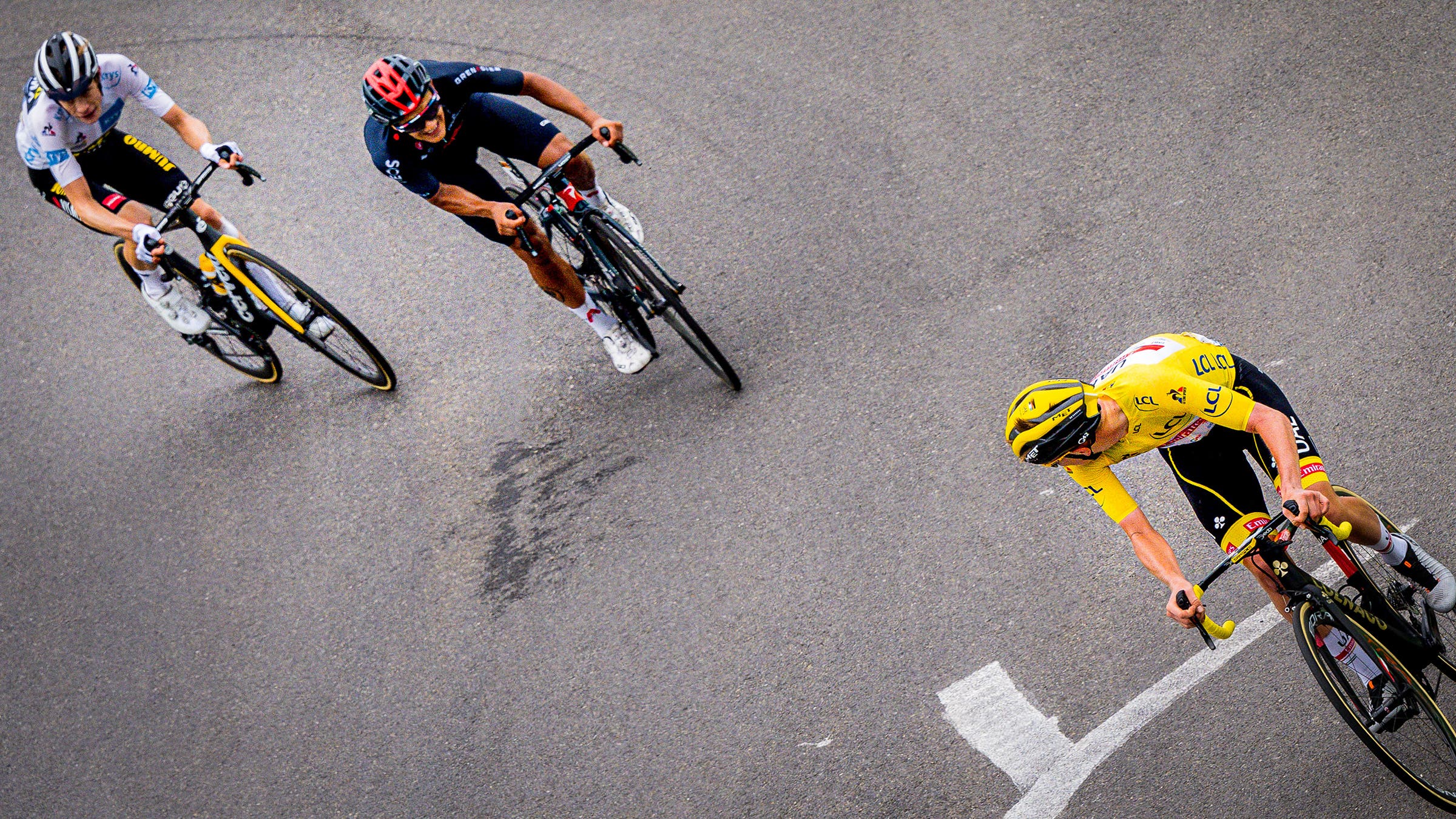 Tadej Pogacar holding Jonas Vingegaard and Richard Carapaz in the final meters of stage 18 of the 2021 Tour de France.