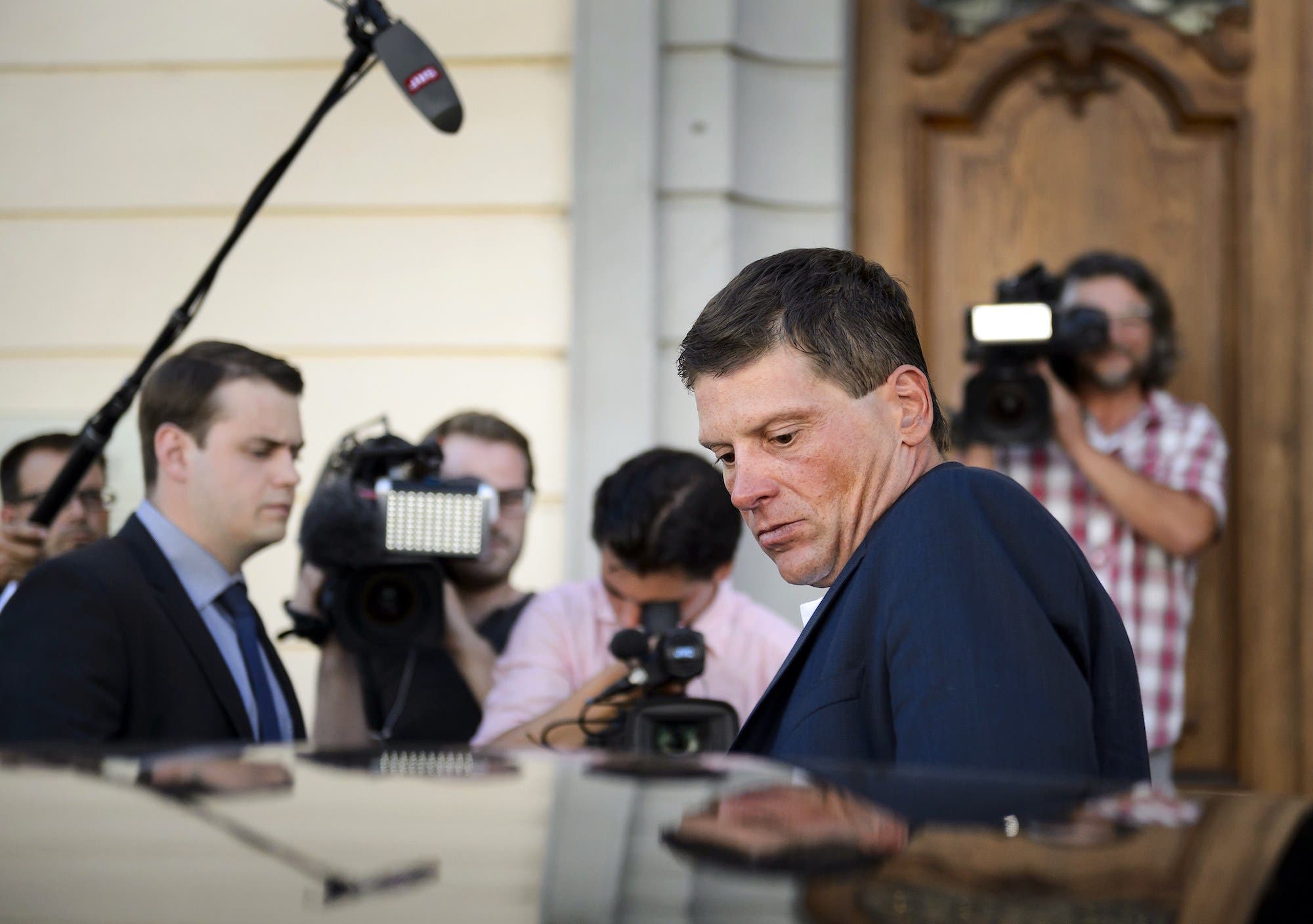 Former German cyclist Jan Ullrich (R) leaves after appearing in court in Weinfelden on July 21, 2015 for his involvement in a three-car crash and driving under the influence of alcohol last year. AFP PHOTO / FABRICE COFFRINI