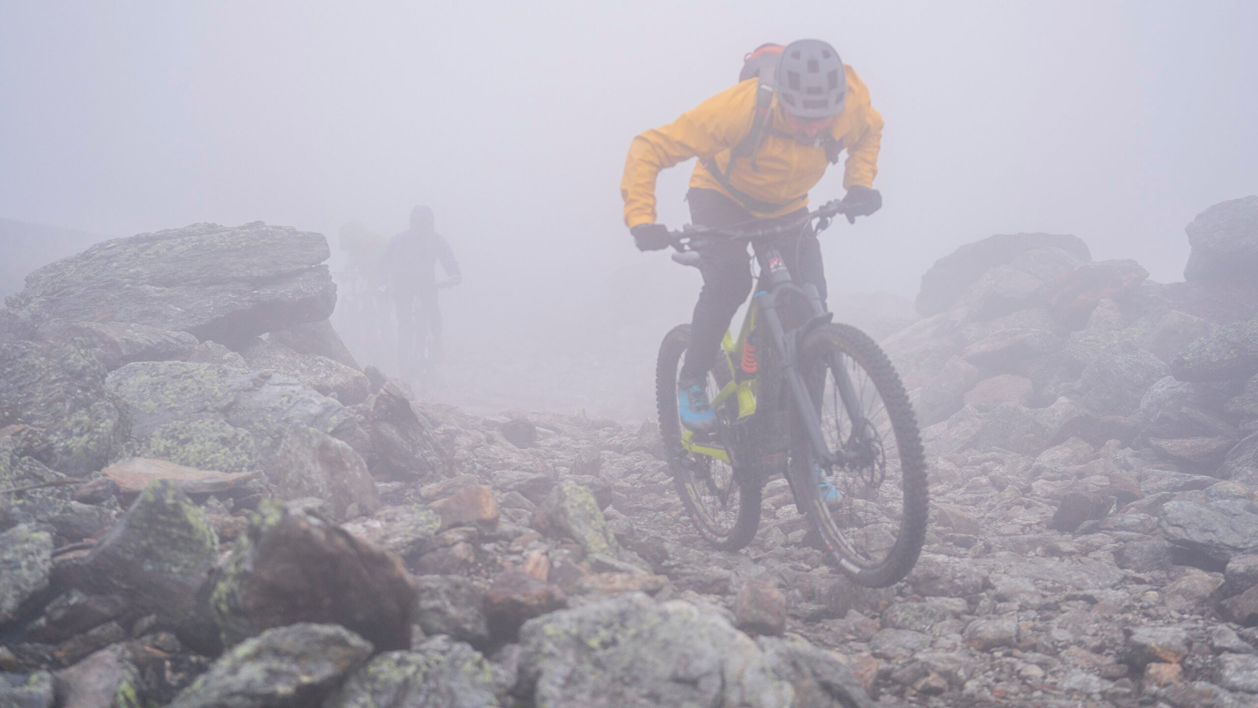 Cyclist mountain biking through fog