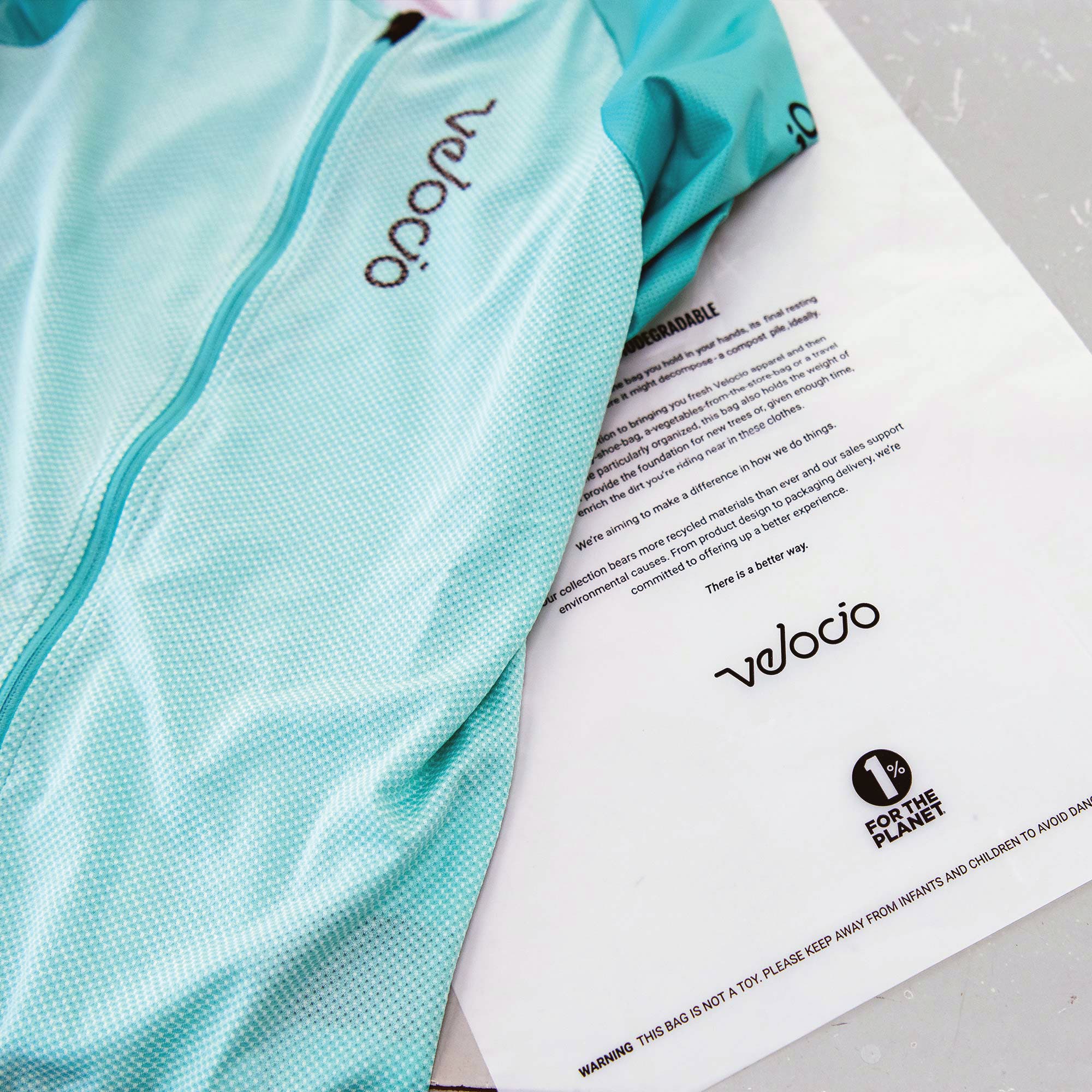 Velocio cycling jersey next to a statement about reducing environmental impact