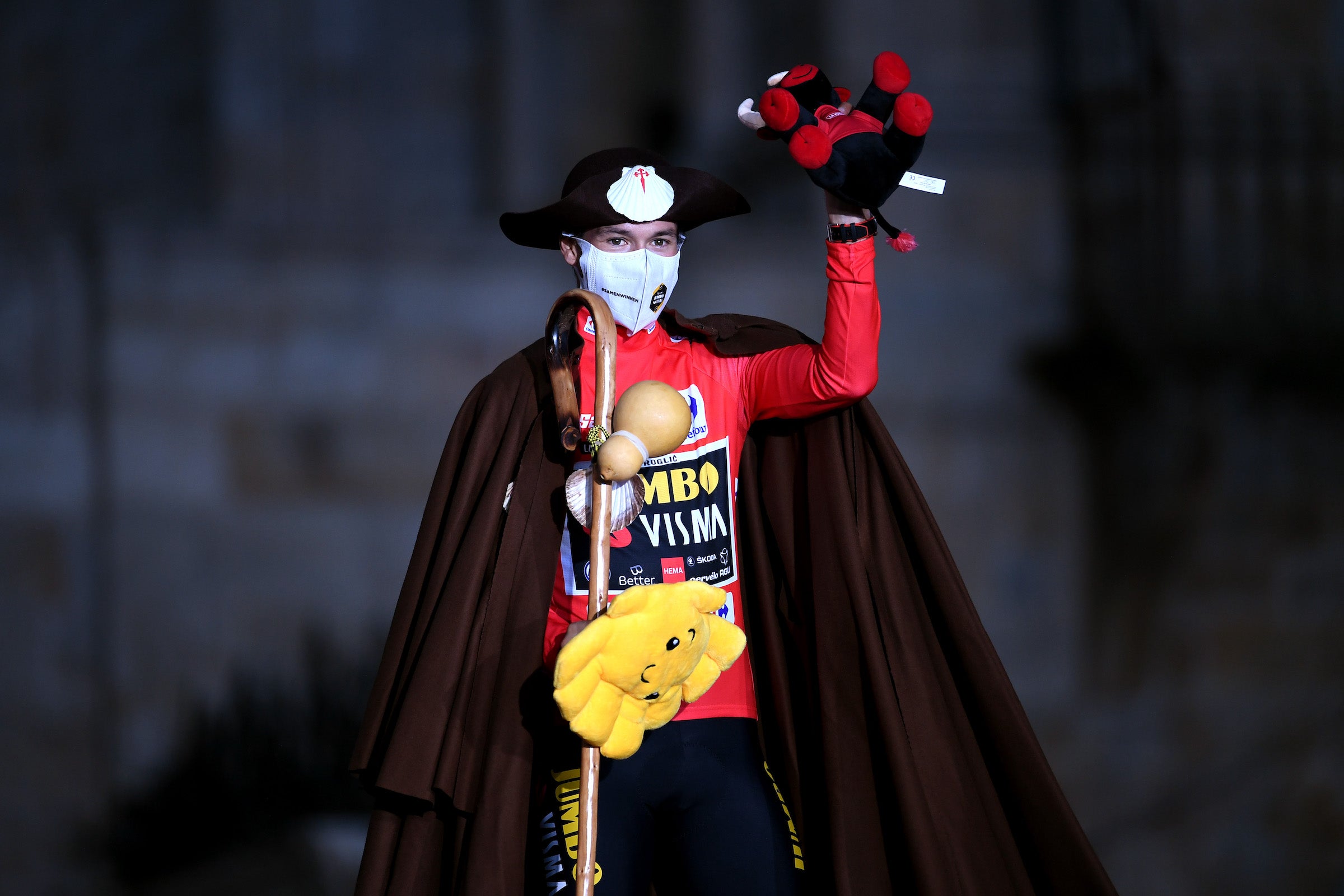 SANTIAGO DE COMPOSTELA, SPAIN - SEPTEMBER 05: Primoz Roglic of Slovenia and Team Jumbo - Visma celebrates winning the red leader jersey dressed in " Camino de Santiago" pilgrim outfit on the podium ceremony in the Plaza del Obradoiro with the Cathedral in the background after the 76th Tour of Spain 2021, Stage 21 a 33,8 km Individual Time Trial stage from Padrón to Santiago de Compostela / @lavuelta / #LaVuelta21 / ITT / on September 05, 2021 in Santiago de Compostela, Spain. (Photo by Tim de Waele/Getty Images)