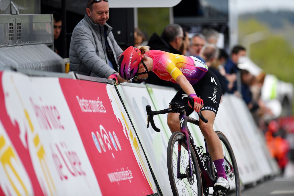 Demi Vollering leans up against the barriers after finishing Fleche Wallonne