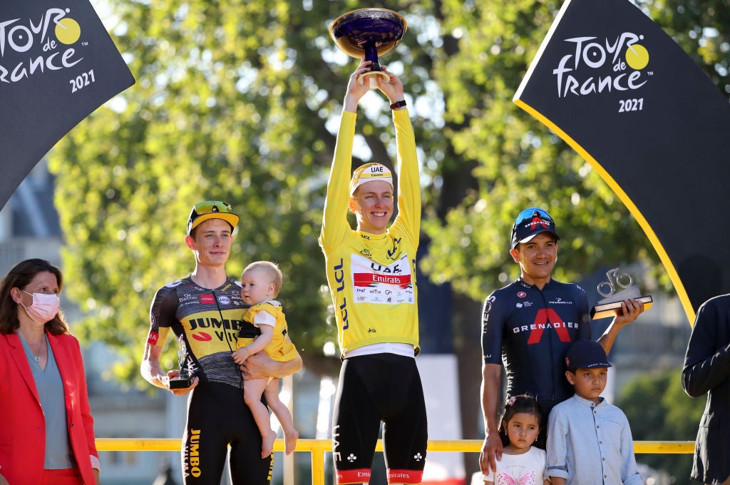 PARIS, FRANCE - JULY 18: From left, second place of the Tour Jonas Vingegaard of Denmark and Jumbo - Visma (with his baby), winner's Yellow Jersey Tadej Pogacar of Slovenia and UAE Team Emirates, third place Richard Carapaz of Ecuador and INEOS Grenadiers (with his children Richard Santiago Carapaz and Aimy Sofia Caparaz) during the trophy ceremony of final stage 21 of the 108th Tour de France 2021, a flat stage of 108,4 km stage from Chatou to Paris Champs-Elysees / @LeTour / #TDF2021 / on July 18, 2021 in Paris, France. (Photo by Jean Catuffe/Getty Images)