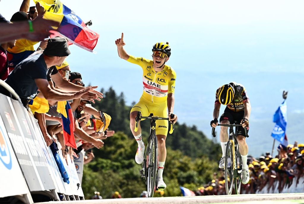 UAE Team Emirates team's Slovenian rider Tadej Pogacar wearing the overall leader's yellow jersey (C) celebrates as cycles past Jumbo-Visma team's Danish rider Jonas Vingegaard (R) to win the 7th stage of the 109th edition of the Tour de France cycling race, 176,3 km between Tomblaine and La Super Planche des Belles Filles, in eastern France, on July 8, 2022. (Photo by Marco BERTORELLO / AFP) (Photo by MARCO BERTORELLO/AFP via Getty Images)