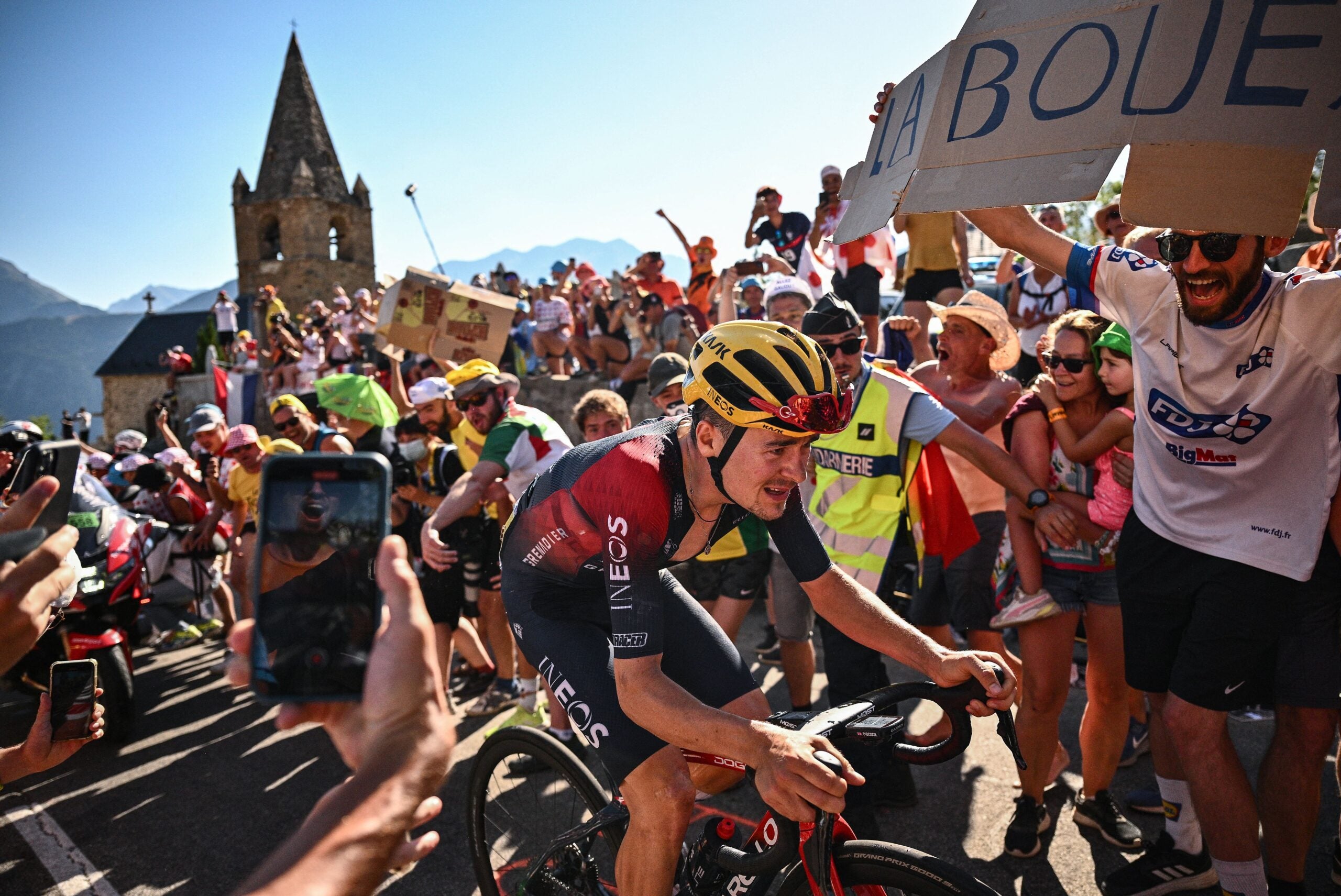 TOPSHOT - Ineos Grenadiers team's British rider Thomas Pidcock cycles in a breakaway past "Dutch corner" in the ascent of Alpe d'Huez during the 12th stage of the 109th edition of the Tour de France cycling race, 165,1 km between Briancon and L'Alpe-d'Huez, in the French Alps, on July 14, 2022. (Photo by Marco BERTORELLO / AFP) (Photo by MARCO BERTORELLO/AFP via Getty Images)