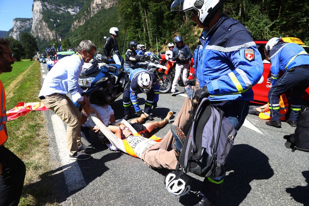 A protestor is dragged from the road during atage 10 of the Tour de France