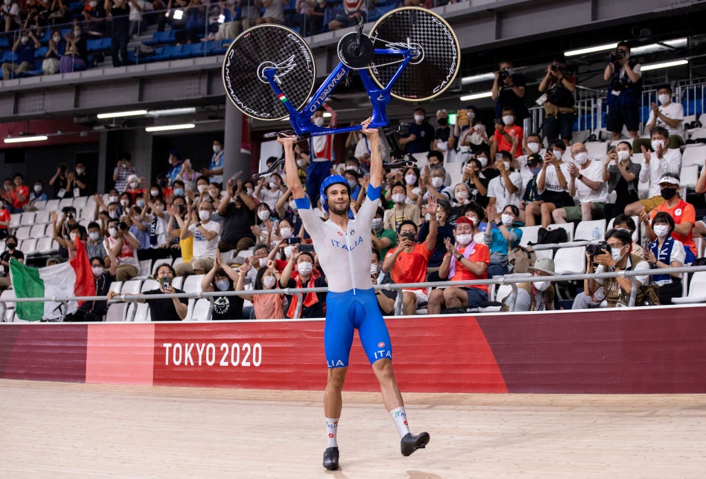 IZU, JAPAN - AUGUST 04: Filippo Ganna of Team Italy lifts his bike to celebrates winning a gold medal after setting a new World record during the Men's team pursuit finals, gold medal of the track cycling on day twelve of the Tokyo 2020 Olympic Games at Izu Velodrome on August 04, 2021 in Izu, Japan. (Photo by Justin Setterfield/Getty Images)
