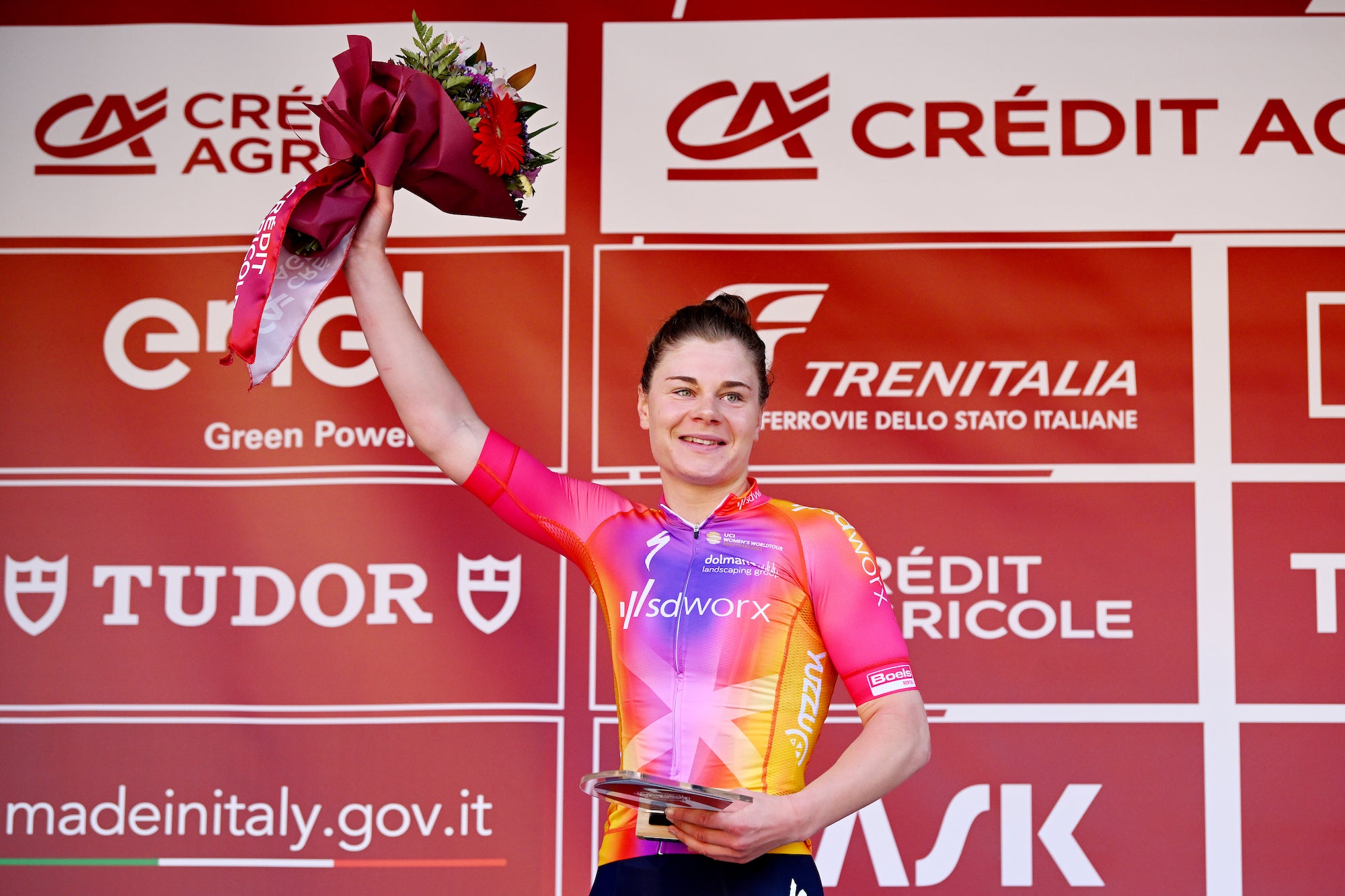 Lotte Kopecky, shown here on the podium at Strade Bianche, will keep racing despite a recent family tragedy.