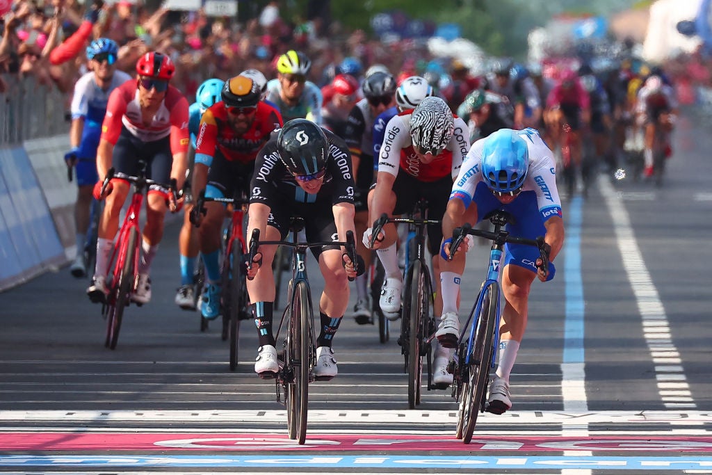 Team DSM's Italian rider Alberto Dainese (C) sprints across the finish line to win the seventeenth stage ahead of third-placed Team Jayco AlUla's Australian rider Michael Matthews (R) during the Giro d'Italia 2023 cycling race, 197 km between Pergine Valsugana and Caorle, near Venice on May 24, 2023. (Photo by Luca Bettini / AFP) (Photo by LUCA BETTINI/AFP via Getty Images)